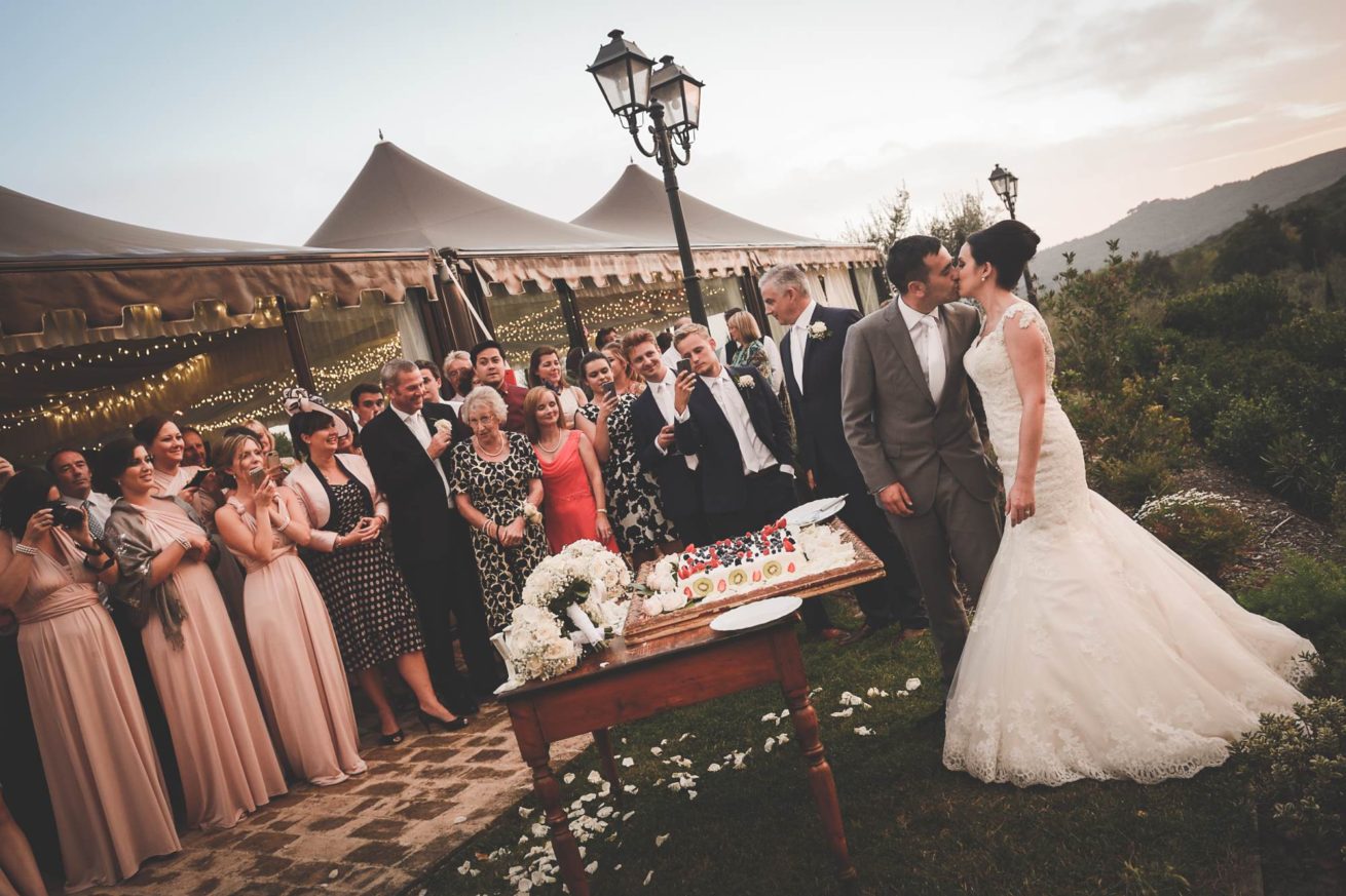 Marquee Wedding Ideas. Bride and groom cutting of the cake outside the marquee.