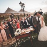 Marquee Wedding Ideas. Bride and groom cutting of the cake outside the marquee.